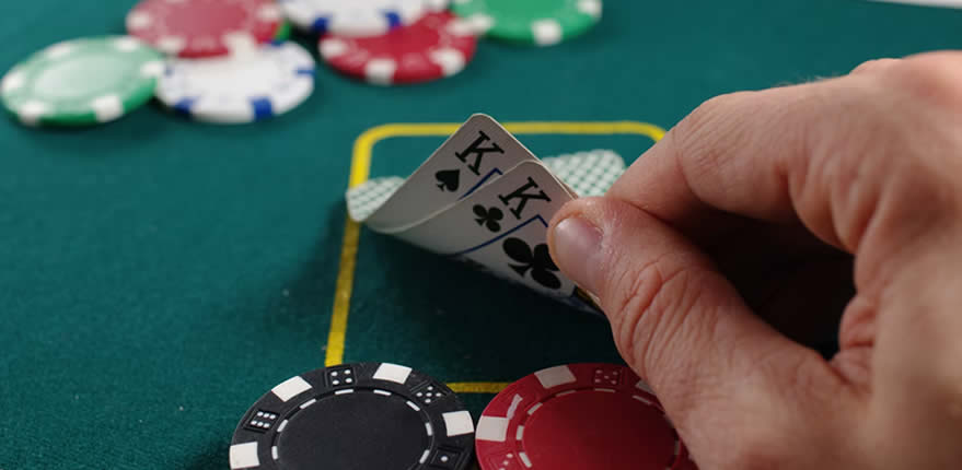 Ein Pokerspieler guckt sich sein Blatt an